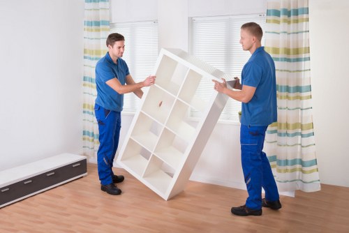 Local movers handling bulky furniture in a Merton flat